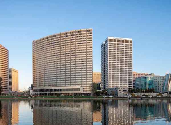 A view of Lake Merritt with two buildings in the foreground.