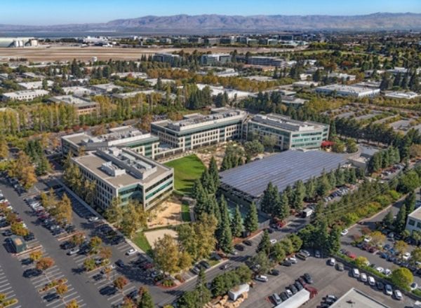 Aerial view of a business campus surrounded by trees and parking areas.